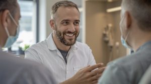 Dentist smiling and talking to patients